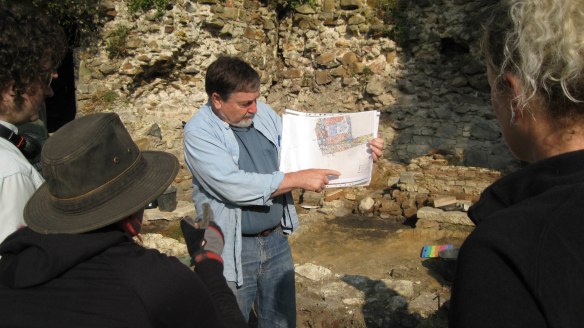 Bailey K. Young orienting students to the features in the Renaissance  portion of the Walhain Castle using a map color coded to the stone types,  prepared by Erika Weinkauf, PhD student at the CRAN and field director of  the excavation (photo: Debra Reid)